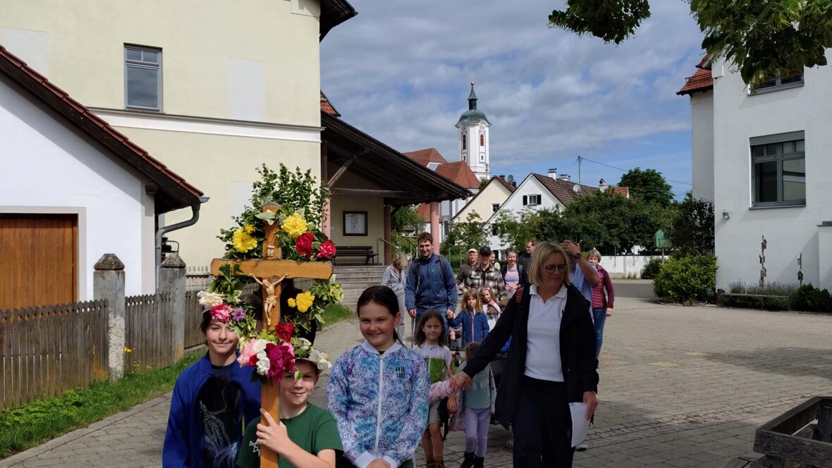 Die Kinder starten mit dem geschmückten Kreuz am Pfarrheim
