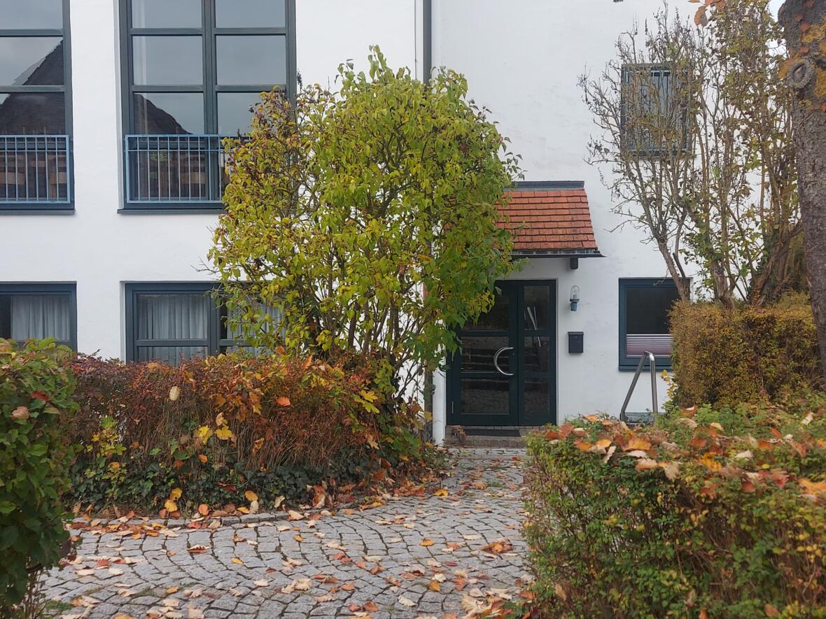 Eingang der KJG Thalfingen im Pfarrzentrum, umgeben von buntem Herbstlaub.